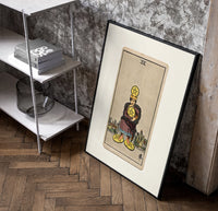 Man clutching gold pentacle coins poster in a black frame leaning beside a shelf in a raw-plaster loft