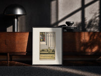 Black-framed Effigy of knight with three swords print on a moody console with designer coffee-table books