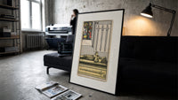 Effigy of knight with three swords print in a slim black frame leaning on a dark sofa in a concrete print studio