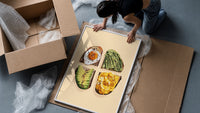 Four Toasts Grid framed print being unpacked from protective bubble wrap and a box