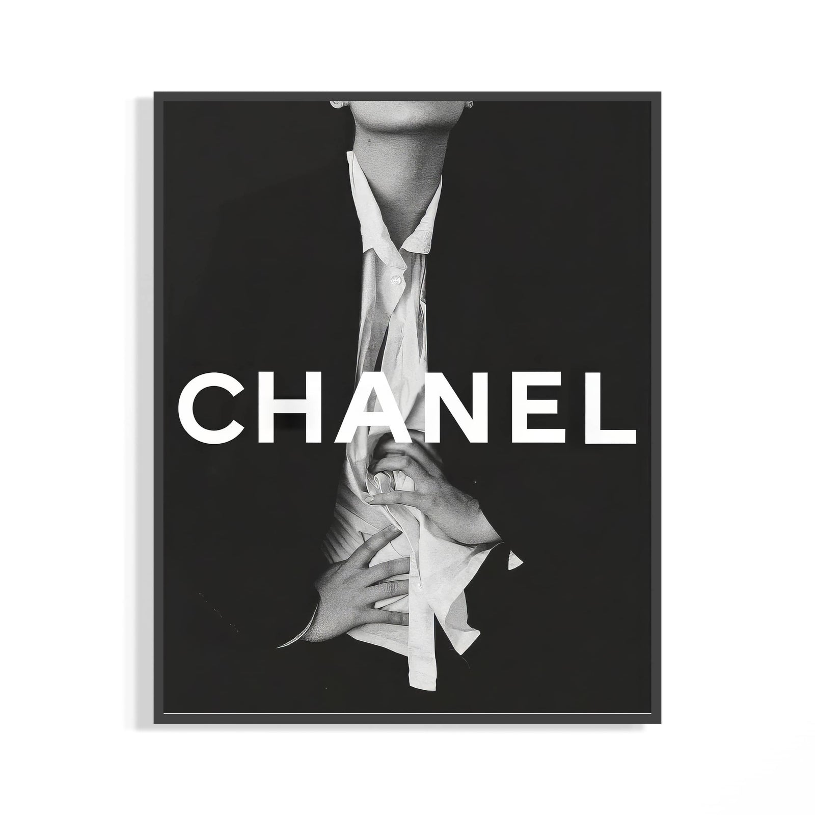 Framed Chanel black and white fashion poster with bold white CHANEL typography and an editorial figure in an open shirt