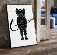 KAWS Chum figure with swoosh line framed poster on white print in a black frame leaning beside a vintage door on parquet