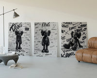KAWS black and white graffiti framed poster set of 3 three-panel set displayed beside a brown leather sofa
