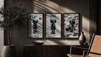 KAWS black and white graffiti framed poster set of 3 triptych in three walnut frames above a sideboard in a warm room