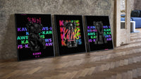 Black KAWS Companion framed poster set of 3 on rainbow tag walls three-piece set leaning on parquet beside a vintage loft…