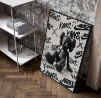 Sitting KAWS Companion framed poster poster in a black frame leaning beside a shelf in a raw-plaster loft