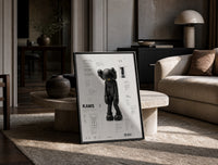 KAWS Companion technical spec sheet framed poster on cream print in a black frame leaning on a travertine table in a…