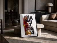 Lewis Hamilton 44 Ferrari red framed F1 poster with cut-out type print in a black frame leaning on a travertine table in…