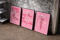 Pink furry KAWS Companion framed poster set of 3 set of three black-framed prints leaning against a raw-plaster wall