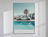 Cream Porsche 911 poolside framed car poster with palms poster in a slim frame on a bright wall with soft window light