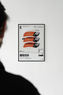Framed salmon sushi lighter Japanese poster on white wall with silhouetted person in foreground