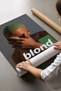Frank Ocean Blond print with gradient green hair laid beside a brown cardboard shipping tube on a table