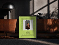 Black-framed Man covering face album cover print on a moody console with designer coffee-table books