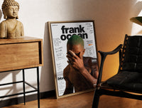 Brass-framed Frank Ocean with green hair print leaning in a warm styled corner by a sculpture