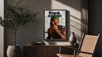Frank Ocean with green hair poster framed above a fluted sideboard beside an olive tree