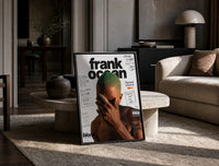 Frank Ocean with green hair print in a black frame leaning on a travertine table in a sunlit lounge