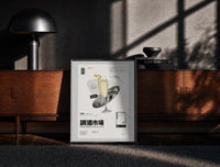 Black-framed French 75 Cocktail Market print on the floor in front of a dark wooden console