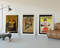 Vintage French aperitif advertisements trio displayed beside a brown leather sofa