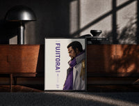 Black-framed Anime marine admiral profile portrait print on a moody console with designer coffee-table books