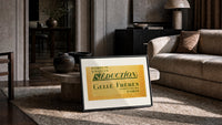 Vintage French perfume label print in a slim black frame leaning on a travertine coffee table