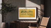 Vintage French perfume label print in a wood frame above a fluted sideboard beside an olive tree