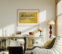 Vintage French perfume label print in an oak frame above a mid-century book console with a vintage radio