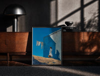 Black-framed Girl Hanging Laundry in the Sun print on the floor in front of a dark wooden console
