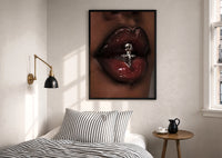 Glossy Lips with a Silver Charm print in a black frame above a bed with striped linens, a brass wall lamp and a sunlit window
