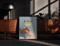 Black-framed Champagne Coupe print on the floor in front of a dark wooden console