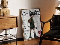 Brass-framed Anime boy with backpack and fishing rod print leaning in a warm styled corner by a sculpture