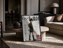 Anime boy with backpack and fishing rod print in a black frame leaning on a travertine table in a sunlit lounge