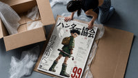 Anime boy with backpack and fishing rod framed print being unpacked from protective bubble wrap and a box