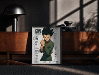 Black-framed anime boy in fighting stance print on a moody console with designer coffee-table books
