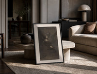 Nightmarish figures with grotesque faces print in a black frame leaning on a travertine table in a sunlit lounge