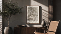 grotesque devils and figures with book poster framed above a fluted sideboard beside an olive tree