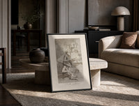 grotesque devils and figures with book print in a black frame leaning on a travertine table in a sunlit lounge