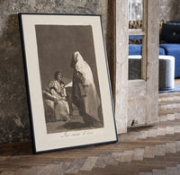 Mother with children fearing hooded figure print in a black frame leaning beside a vintage door on parquet