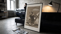grotesque goblins drinking together print in a slim black frame leaning on a dark sofa in a concrete print studio