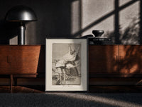 Black-framed Grotesque figures screaming with raised arms print on a moody console with designer coffee-table books
