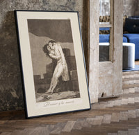 man embracing dying woman print in a black frame leaning beside a vintage door on parquet