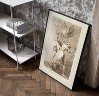 Owl above bound couple poster in a black frame leaning beside a shelf in a raw-plaster loft
