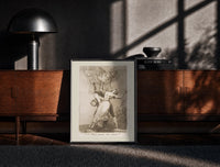 Black-framed Owl above bound couple print on a moody console with designer coffee-table books