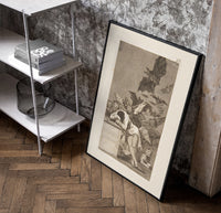 Sleeping man surrounded by owls and bats poster in a black frame leaning beside a shelf in a raw-plaster loft