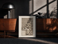 Black-framed Sleeping man surrounded by owls and bats print on a moody console with designer coffee-table books