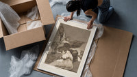 Winged demon carrying frightened figure framed print being unpacked from protective bubble wrap and a box