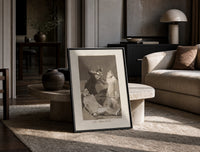 Two figures with locked faces attacked print in a black frame leaning on a travertine table in a sunlit lounge