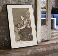 Grotesque figures spinning thread print in a black frame leaning beside a vintage door on parquet