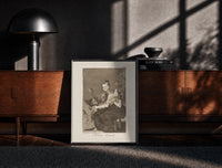 Black-framed Grotesque figures spinning thread print on a moody console with designer coffee-table books