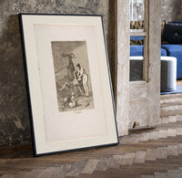 witch scene with goat demon print in a black frame leaning beside a vintage door on parquet