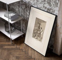 witch scene with goat demon poster in a black frame leaning beside a shelf in a raw-plaster loft